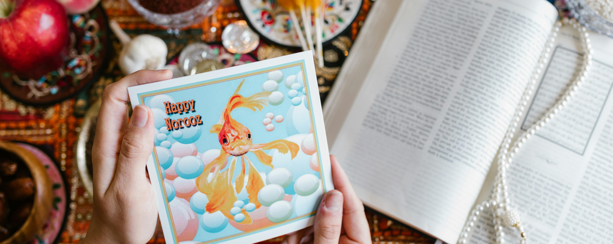 A vibrant display of Haft Seen items with a Happy Norooz card, symbolizing Nowruz celebrations.