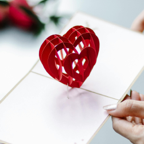 Elegant red heart pop-up card held by a woman, perfect for Valentine's Day celebrations.