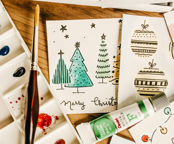 Creative handcrafted Christmas cards with watercolor art using tubes and brush.